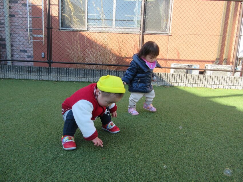 園庭でシャボン玉をしてみると芝生の上にのっかり大喜びで触りに行っていました！